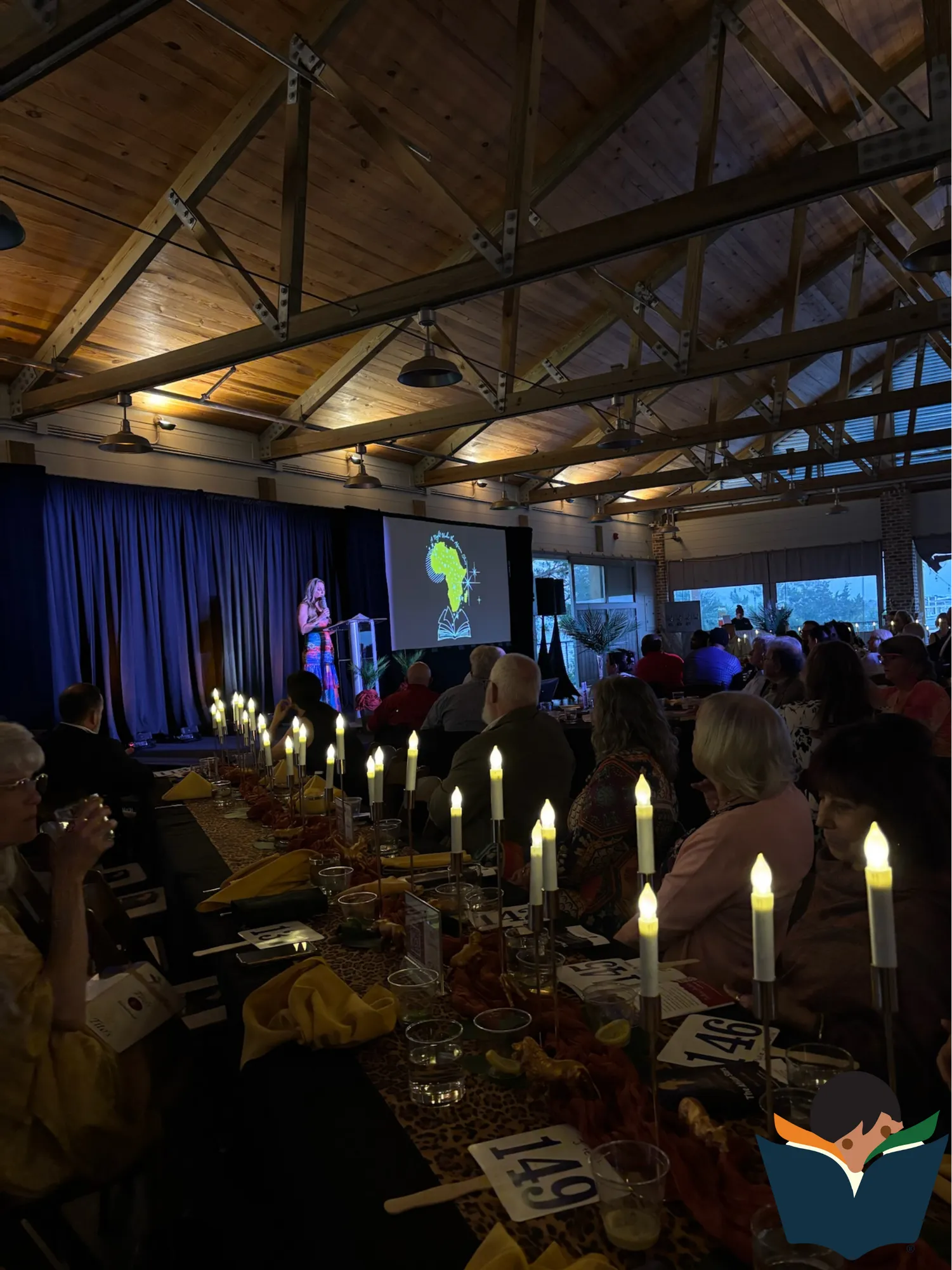 Guests seated at candlelit tables for a World Book Day event